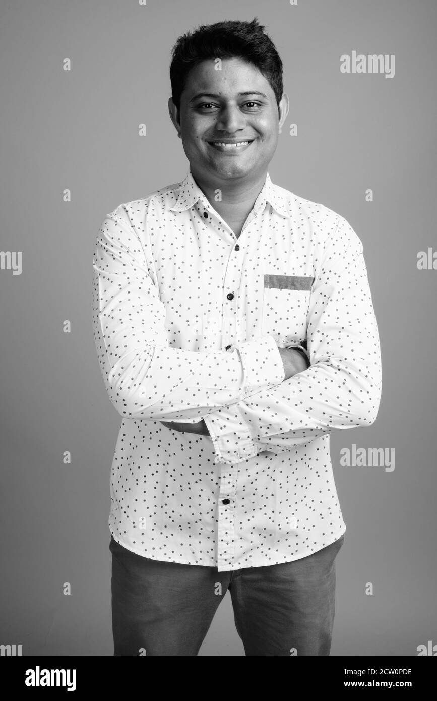 Porträt der jungen indischen Geschäftsmann gegen grauer Hintergrund Stockfoto
