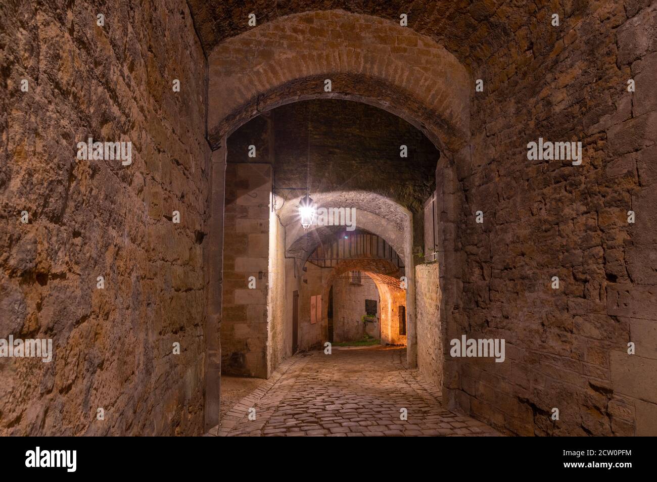 Schattiger Eingang in das riesige Schloss von Sedan, keine Leute, nachts unter Straßenlaternen Stockfoto