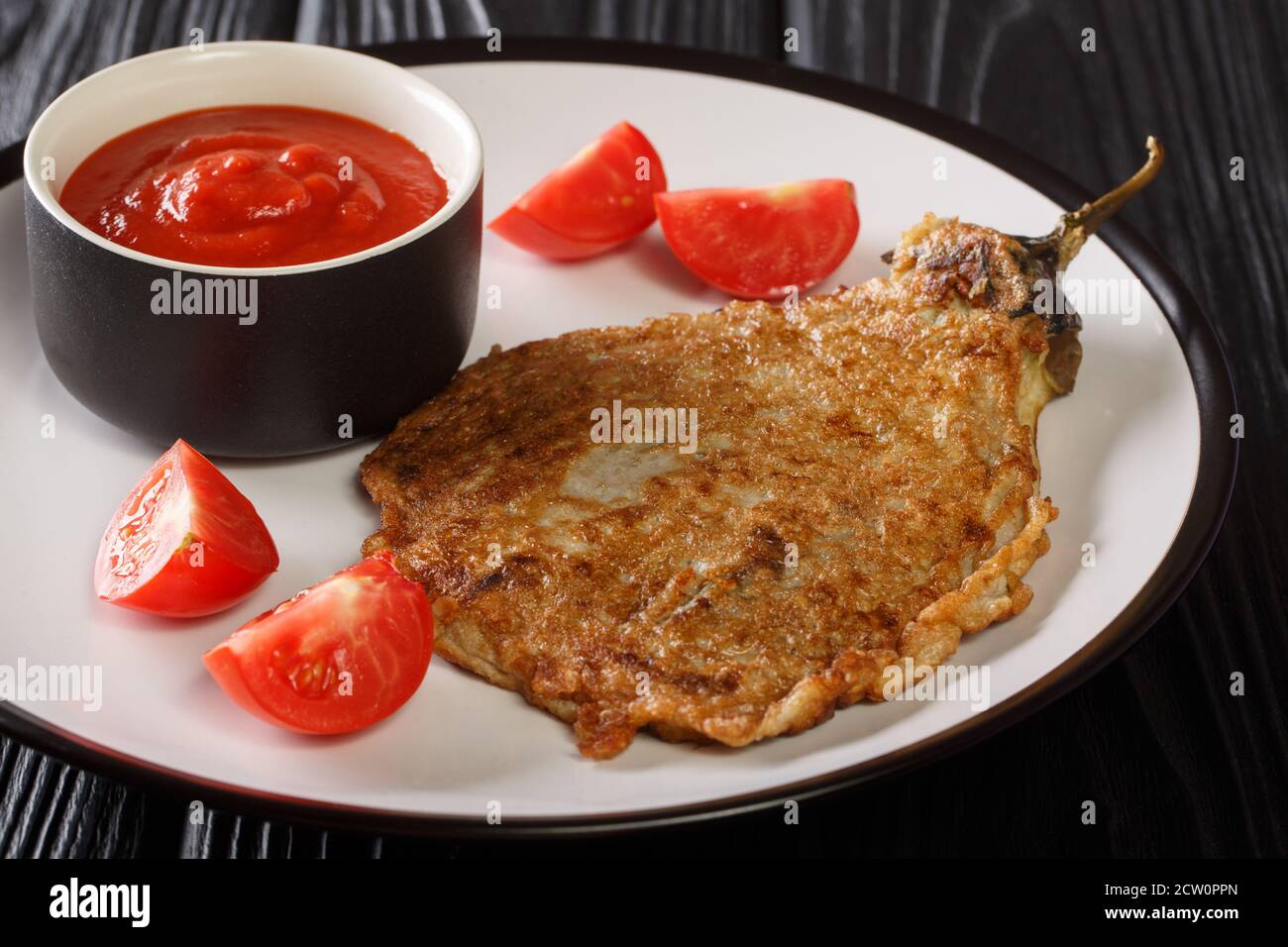 Einfaches philippinisches TischTortang Talong aus einer Kombination von gerösteten Auberginen und leicht geschlagenen Eiern aus der Nähe auf einem Teller auf dem Tisch. Horizontal Stockfoto