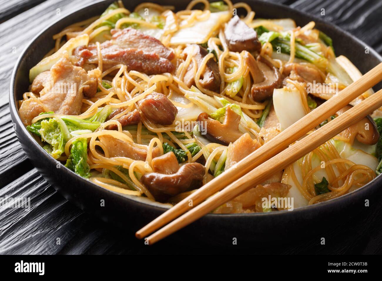 Glas Nudeln mit Schweinebauch, Pilze und napa-Kohl Nahaufnahme in einem Teller auf dem Tisch. Horizontal Stockfoto