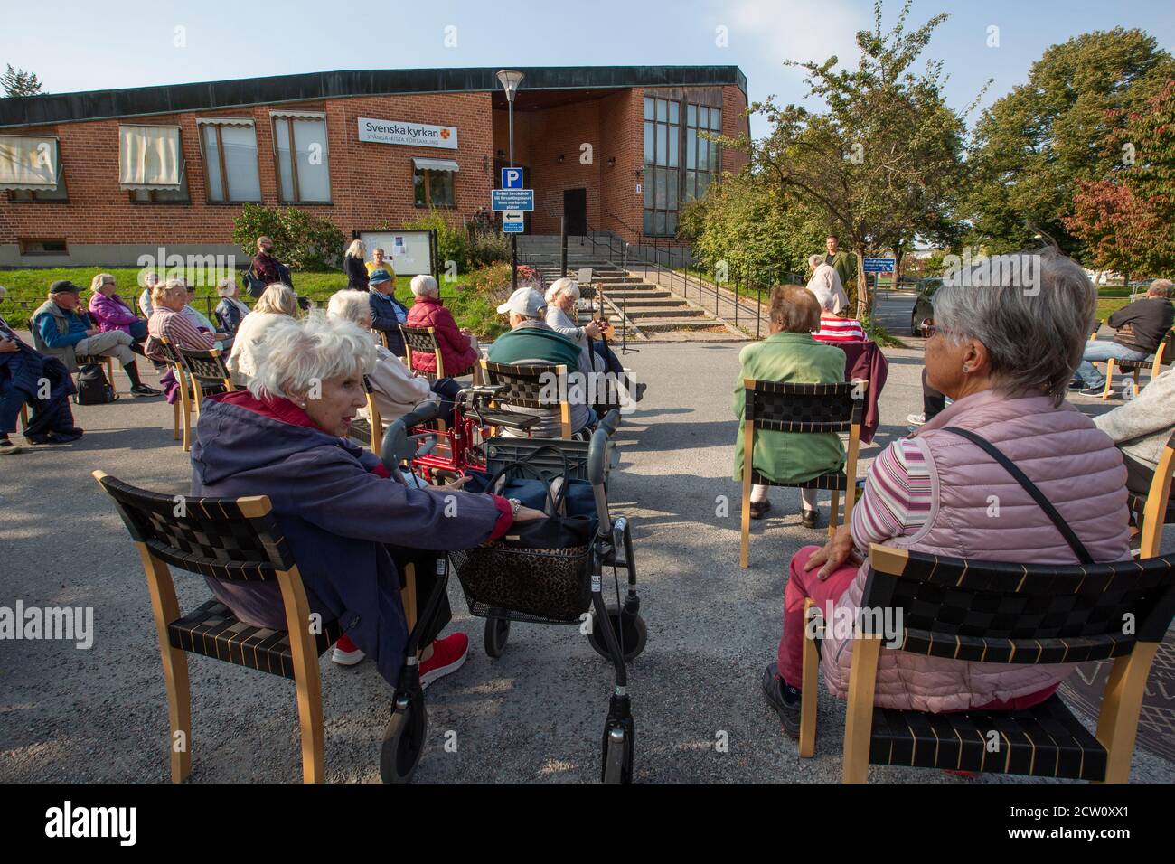 Musikzeit außerhalb der Kirche für ältere Menschen mit einem sicheren Abstand für die covid-19 Pandemie. Stockfoto