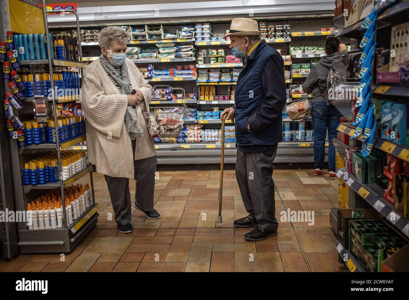 Ältere Paare, die während der Coronavirus-Pandemie in einem Londoner Supermarkt einkaufen, tragen obligatorische Gesichtsmasken, England, Großbritannien Stockfoto
