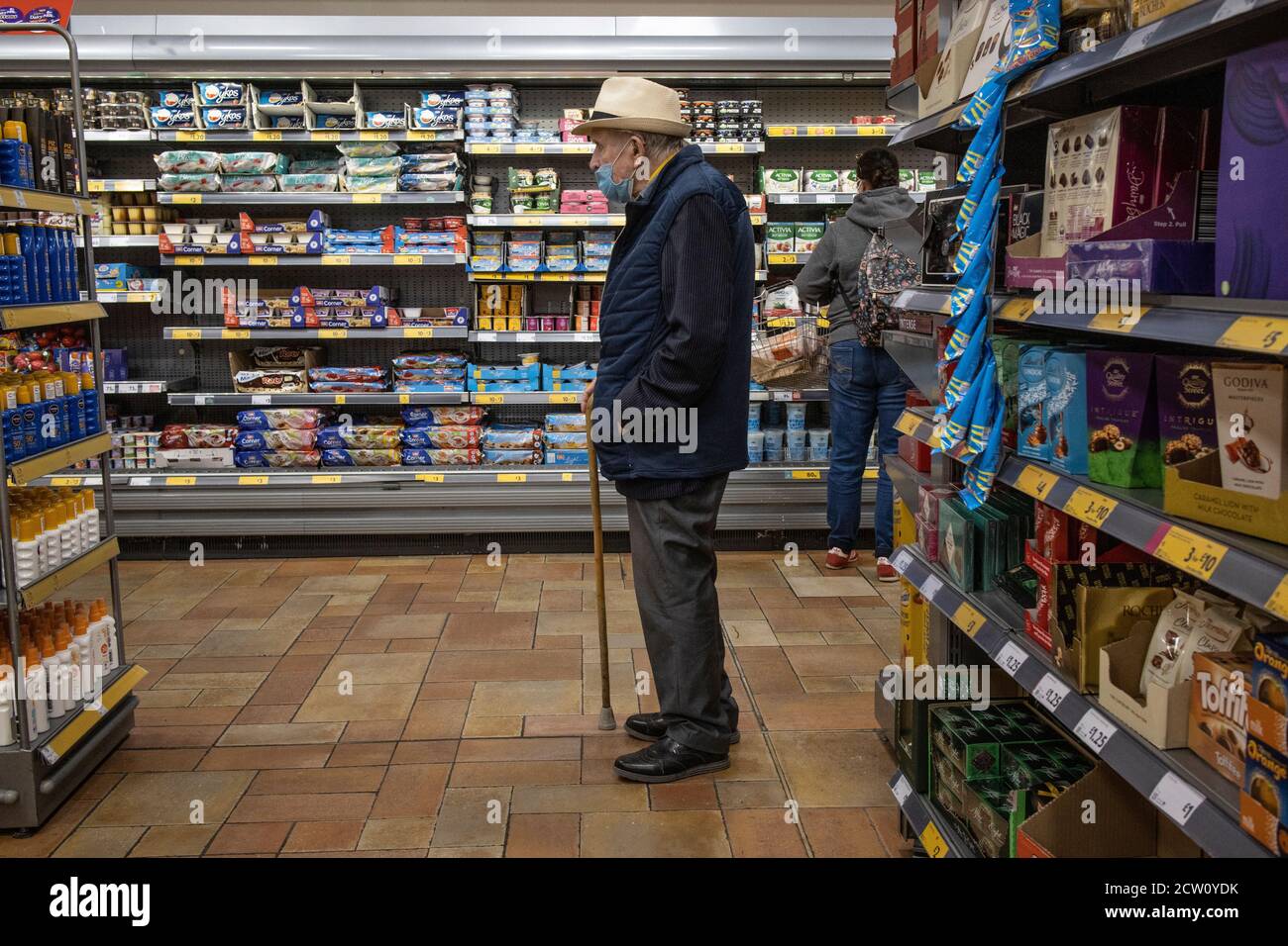 Ältere Paare, die während der Coronavirus-Pandemie in einem Londoner Supermarkt einkaufen, tragen obligatorische Gesichtsmasken, England, Großbritannien Stockfoto