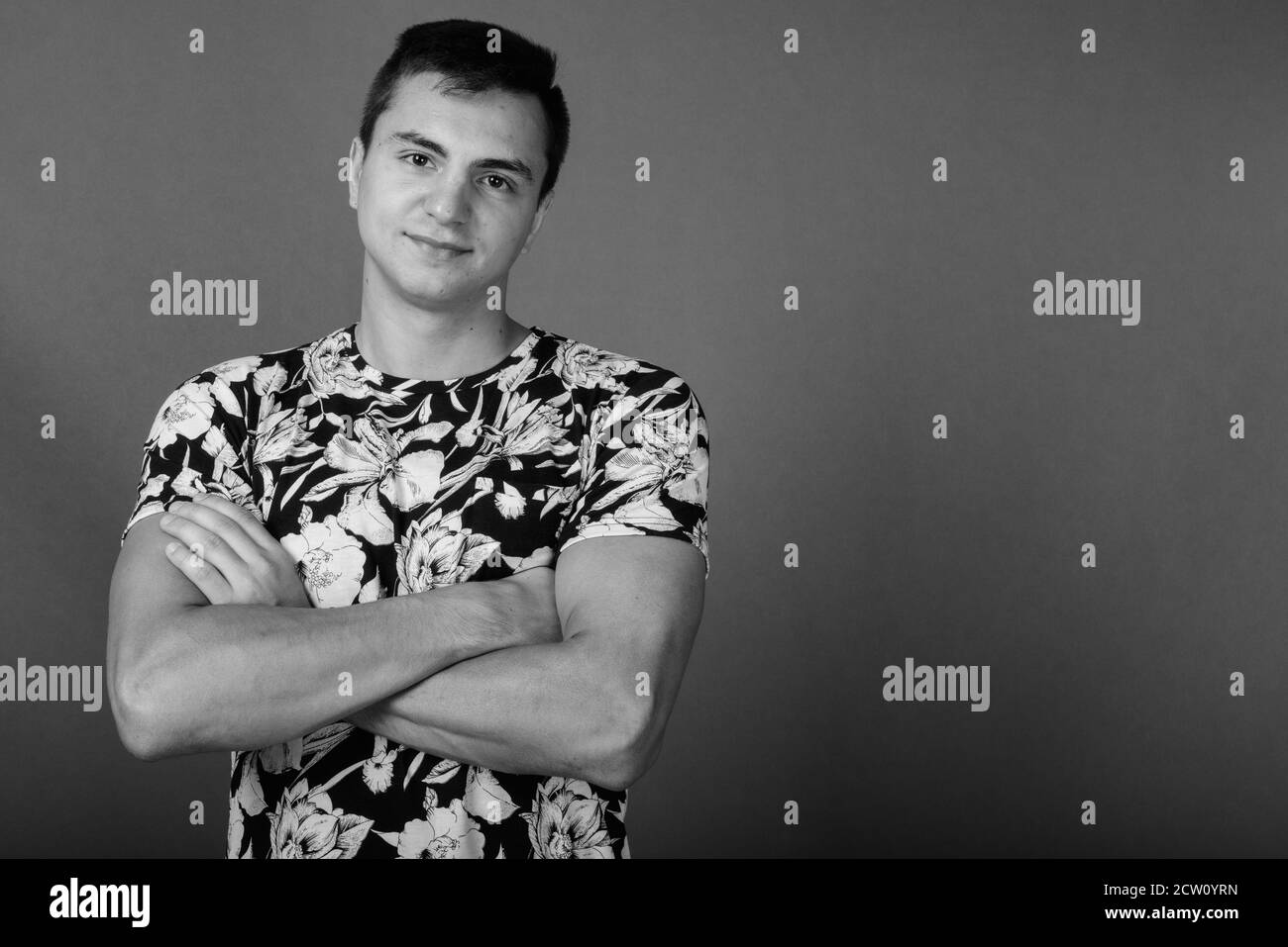 Studio shot Junger stattlicher Mann gegen grauer Hintergrund Stockfoto