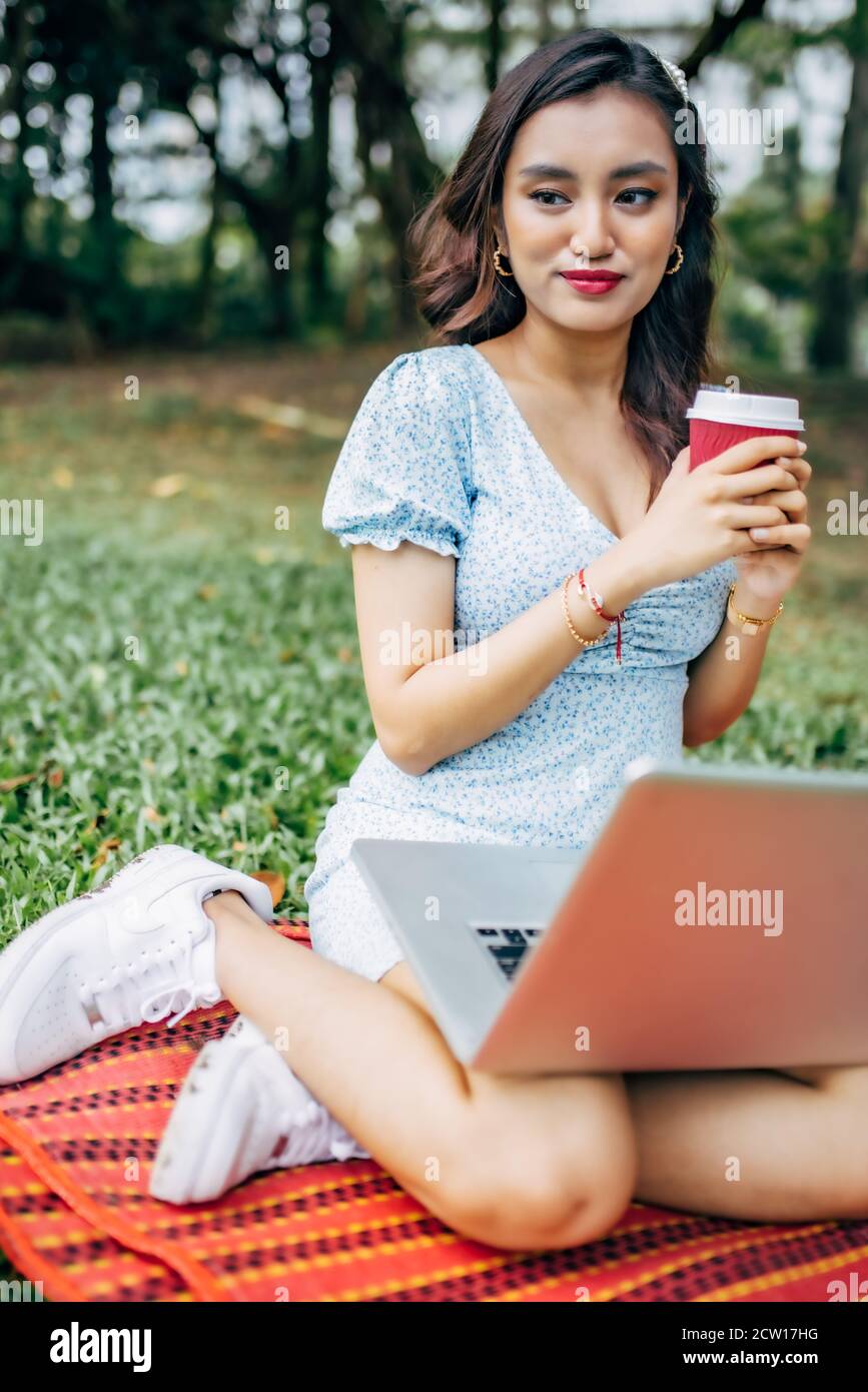 Schöne asiatische Frau, die im Park arbeitet und die schöne Aussicht und die frische Luft genießt. Stockfoto