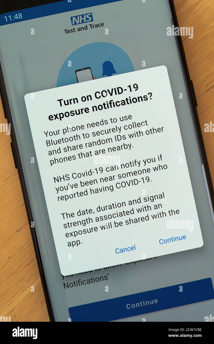 NHS Test and Trace App auf einem Smartphone mit einem Anforderungsbildschirm für Berechtigungen zum Aktivieren von Belichtungsbenachrichtigungen für Covid-19. Bedenken zum Datenschutz Stockfoto