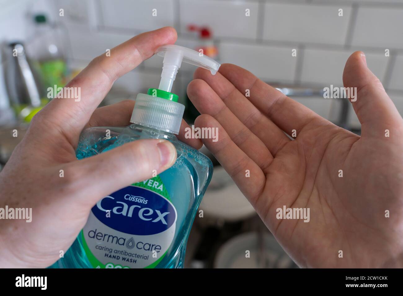Ein Mann, der antibakterielle Händedesinfektionsmittel verwendet, um Flüssigseife in seine Hände zu geben. Konzept Sauberkeit, Händewaschen, Covid-19, Coronavirus, OCD Stockfoto
