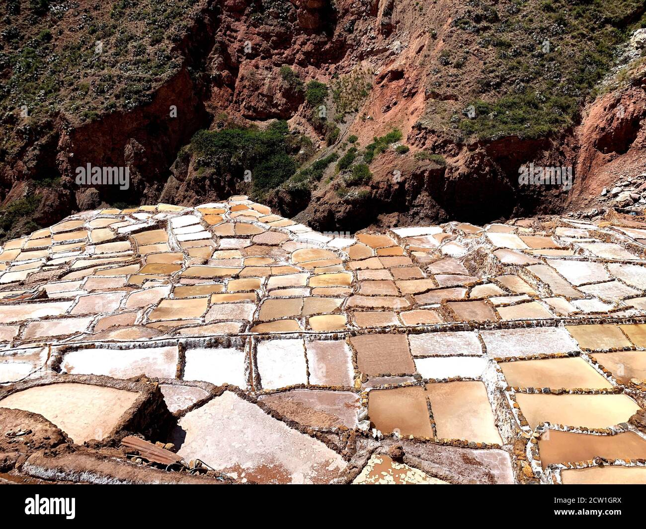 Kaskade von Salzbergwerken Salineras de Maras in peruanischen Anden. Malerische Landschaft mit Salzteichen und Pfannen. Extraktion von Salz in Peru. Stockfoto