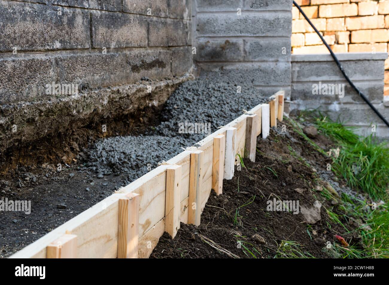Cernment , Beton Graben Füllung bis zur Wand zu Hause Garten zu unterstützen Stockfoto