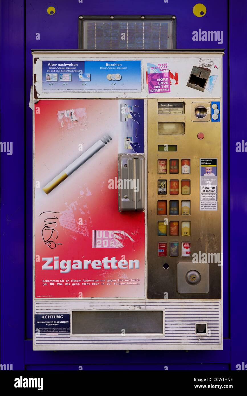 An einer Wand steht ein klassischer Zigarettenautomaten. Stockfoto