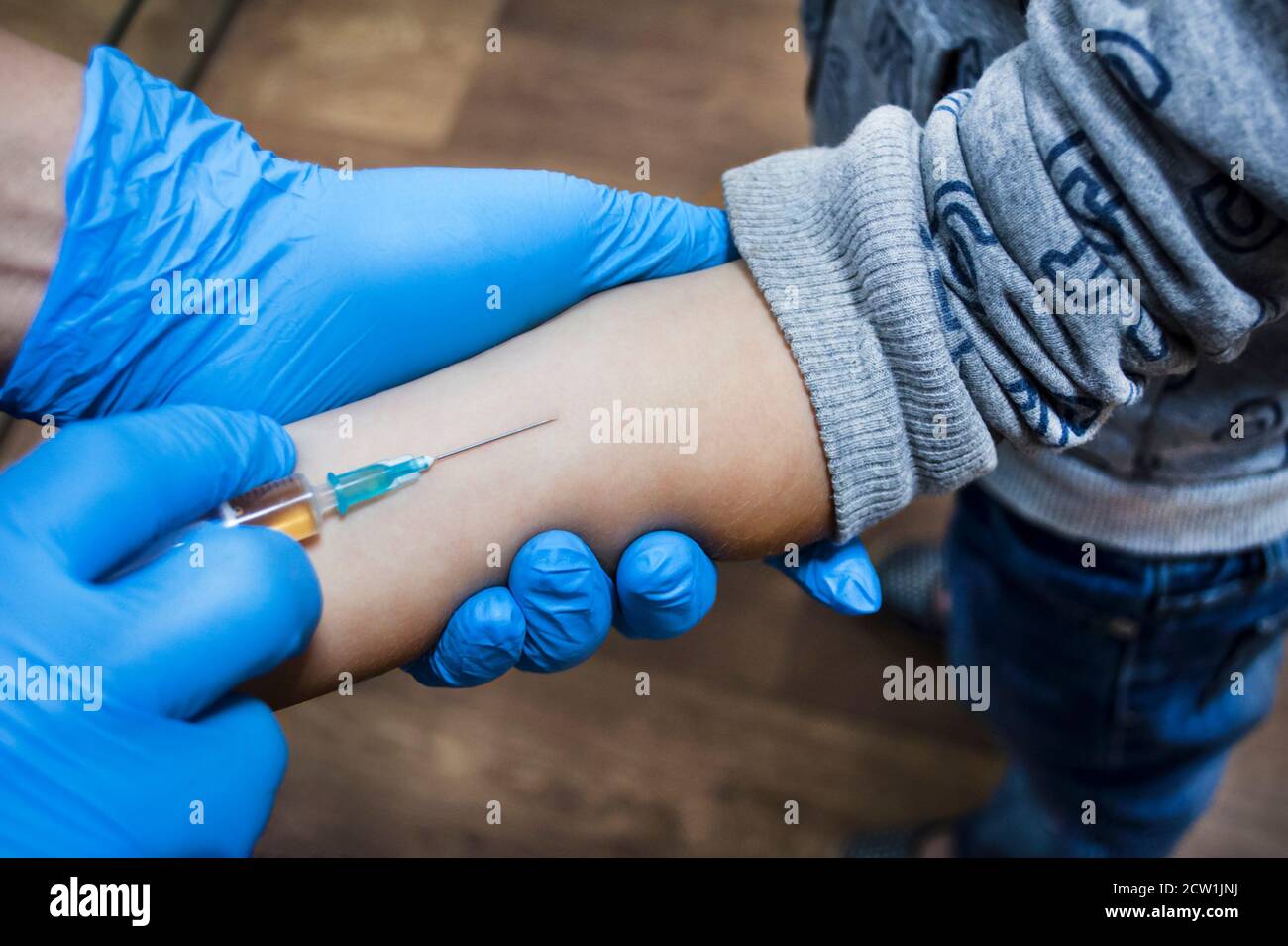 Der Arzt wird einem Kind eine Injektion geben Von 5 Jahren im Unterarm Stockfoto