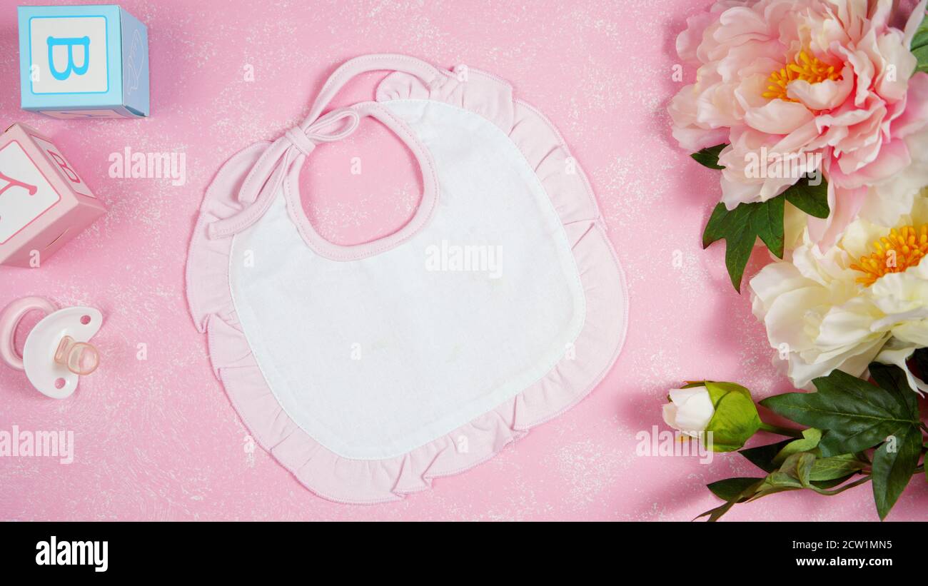Baby Lätzchen Baumschule Kleidung Mama Blogger Desktop-Mockups mit peonie floers auf rosa strukturierten Hintergrund. Top Ansicht Blog Held Header kreative Komposition Stockfoto