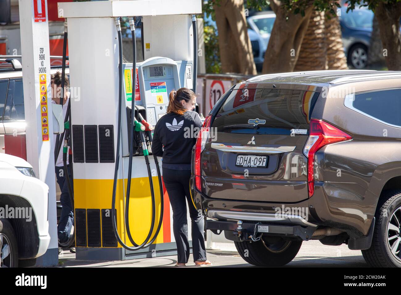 Frau, die bei einer Shell in Sydney Kraftstoff in ihr Auto legt Tankstelle, Sydney, Australien Stockfoto