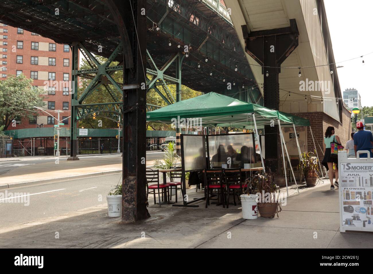 Restaurant Esstische mit Trennwänden unter dem erhöhten aufgestellt U-Bahn-Gleise an der 125th Street und Bdwy in Harlem Einhaltung von Vorschriften Stockfoto