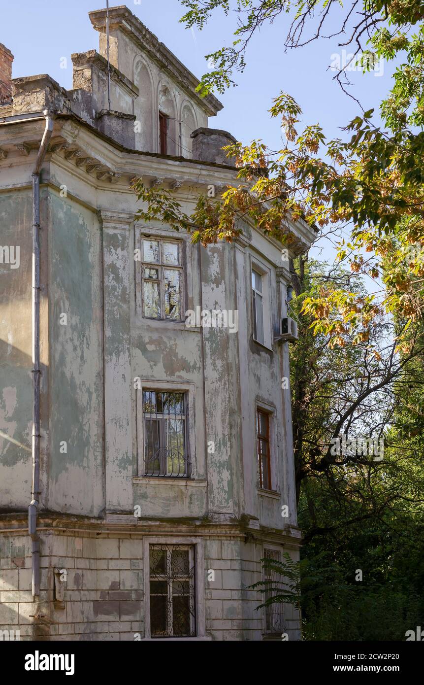 Verfallene Fassade eines alten Gebäudes in einem Herbstpark. Dreistöckiges Gebäude aus dem 19. Jahrhundert, renovierungsbedürftig. Historische Architektur Stockfoto