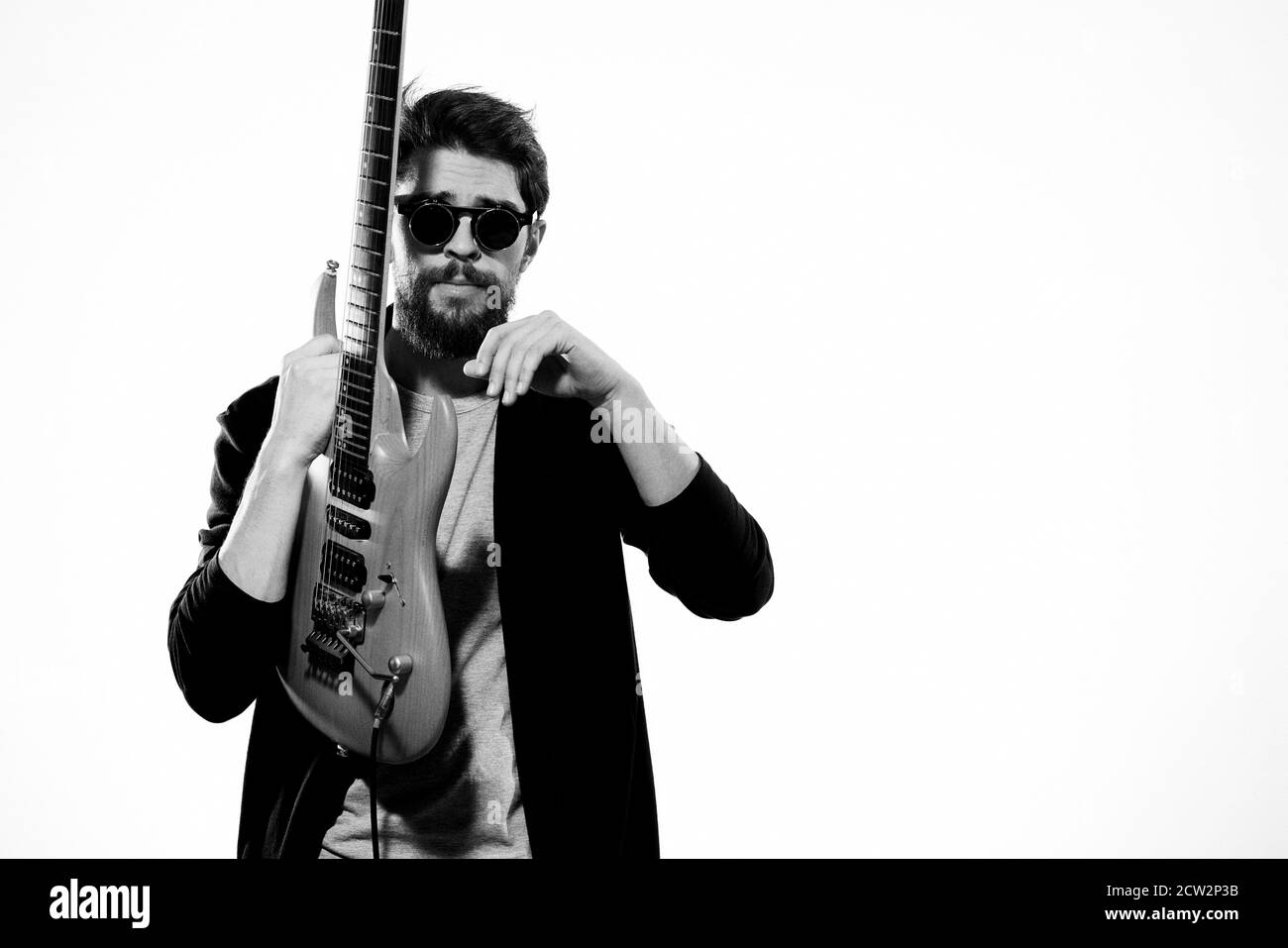 Ein Mann mit einer Gitarre Emotionen Musik Spiel Performance Leder Jacke Sonnenbrille Licht Hintergrund Stockfoto