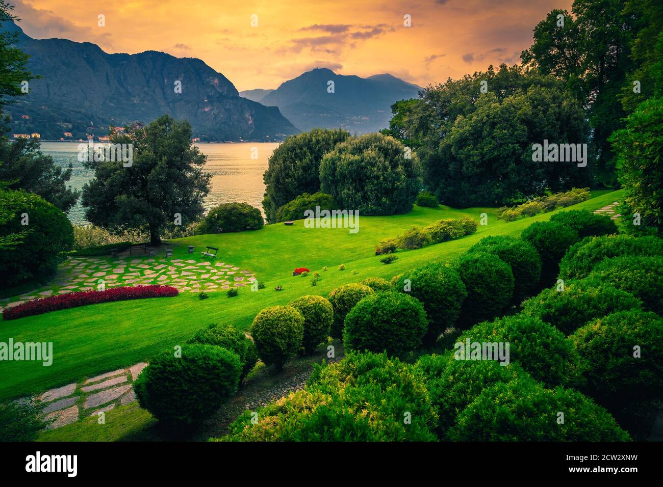Gehweg und Ruheplatz im wunderschönen Ziergarten bei Sonnenuntergang, Comer See, Lombardei, Italien, Europa Stockfoto