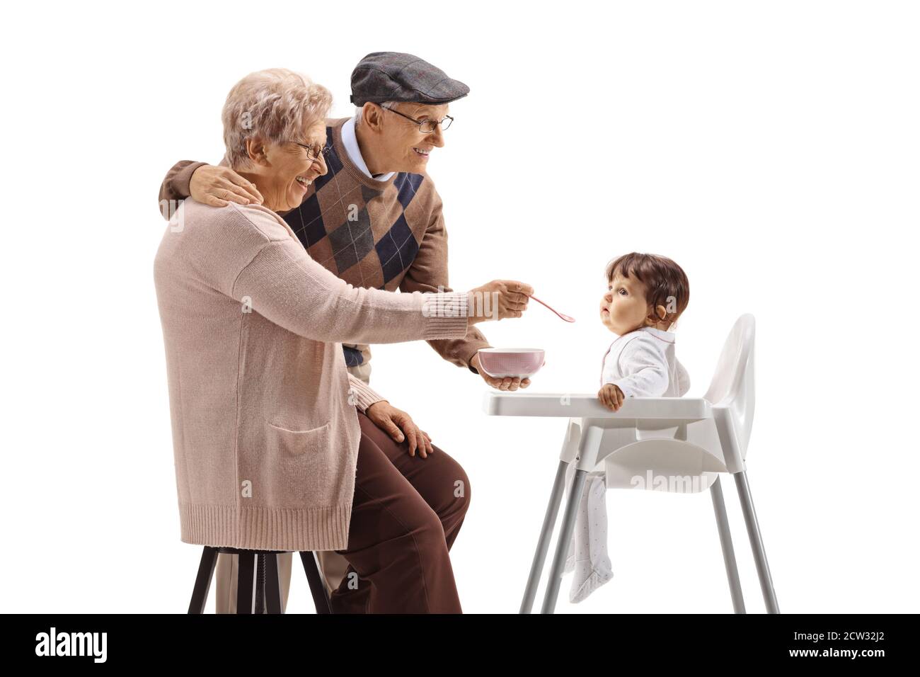 Großmutter und Großvater füttern ein Baby in einem Stuhl isoliert Auf weißem Hintergrund Stockfoto