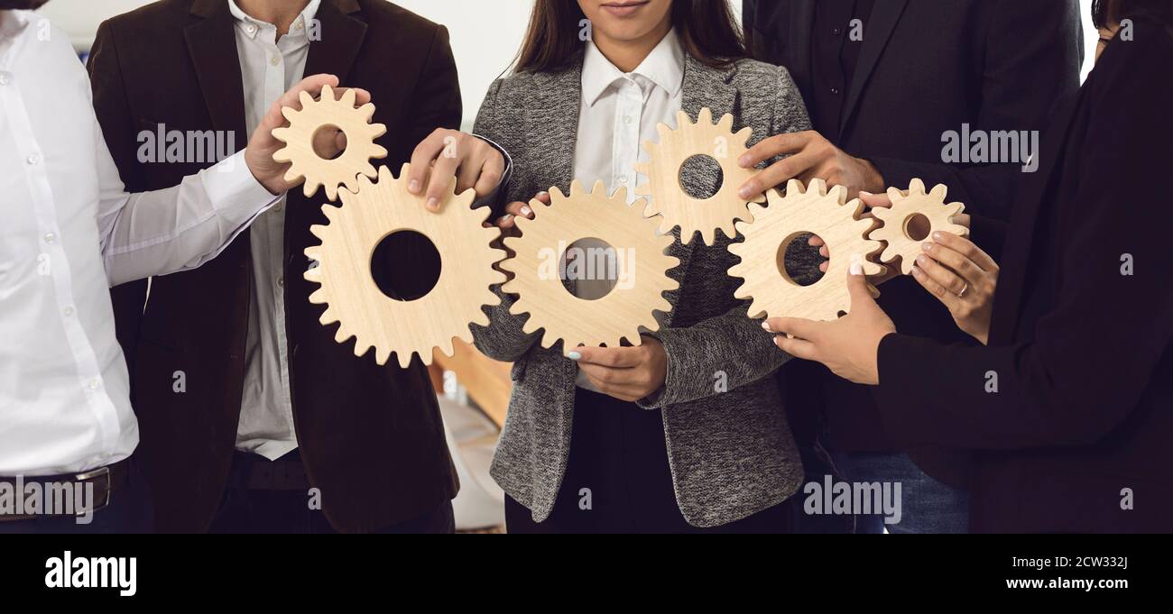Mitarbeiter des Unternehmens, die Zahnräder als Metapher für eine effektive Unternehmensführung verbinden Und Teamarbeit Stockfoto