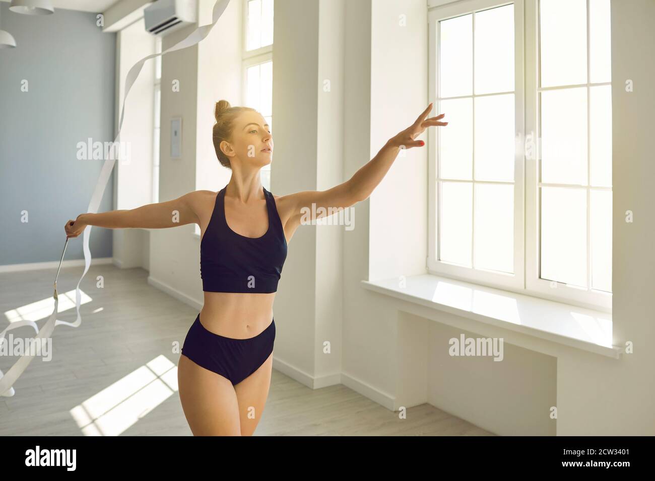 Mädchen Turnerin üben rhythmische Gymnastik mit Band Stockfoto