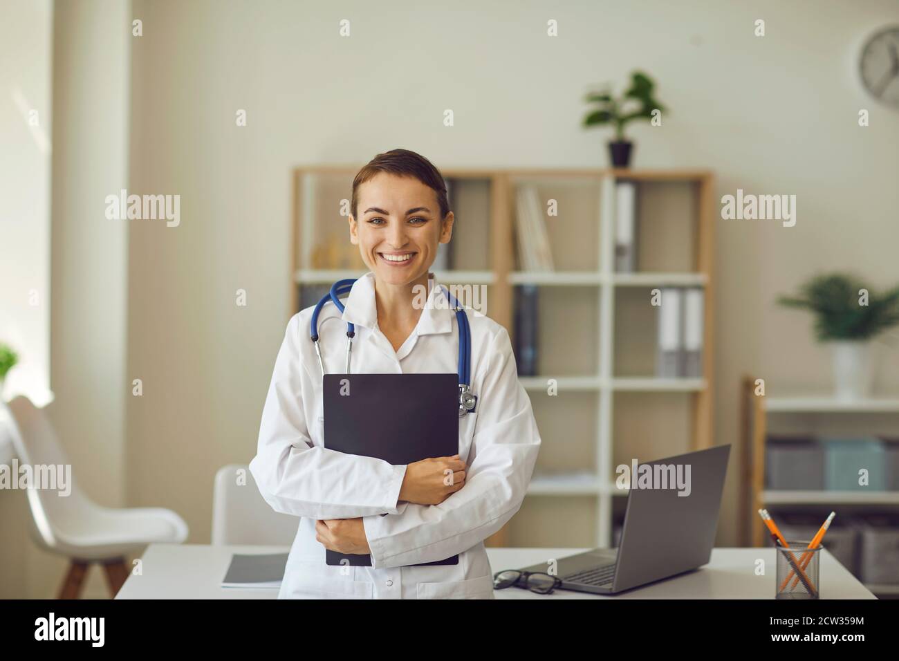 Frau Arzt Blick auf Kamera und lächeln während Online-Medizin Beratung in der Klinik Stockfoto