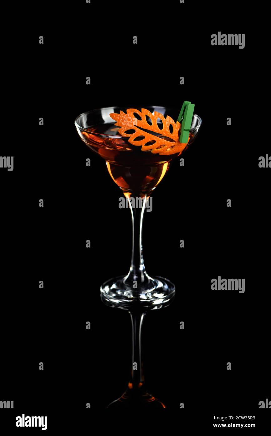 Kunst in Orange - Früchte schnitzen. Wie man zu Zitrusfrüchten garnieren Design für ein Getränk zu machen. Cocktail Rob Roy. Whiskey-basierte Getränke. Stockfoto
