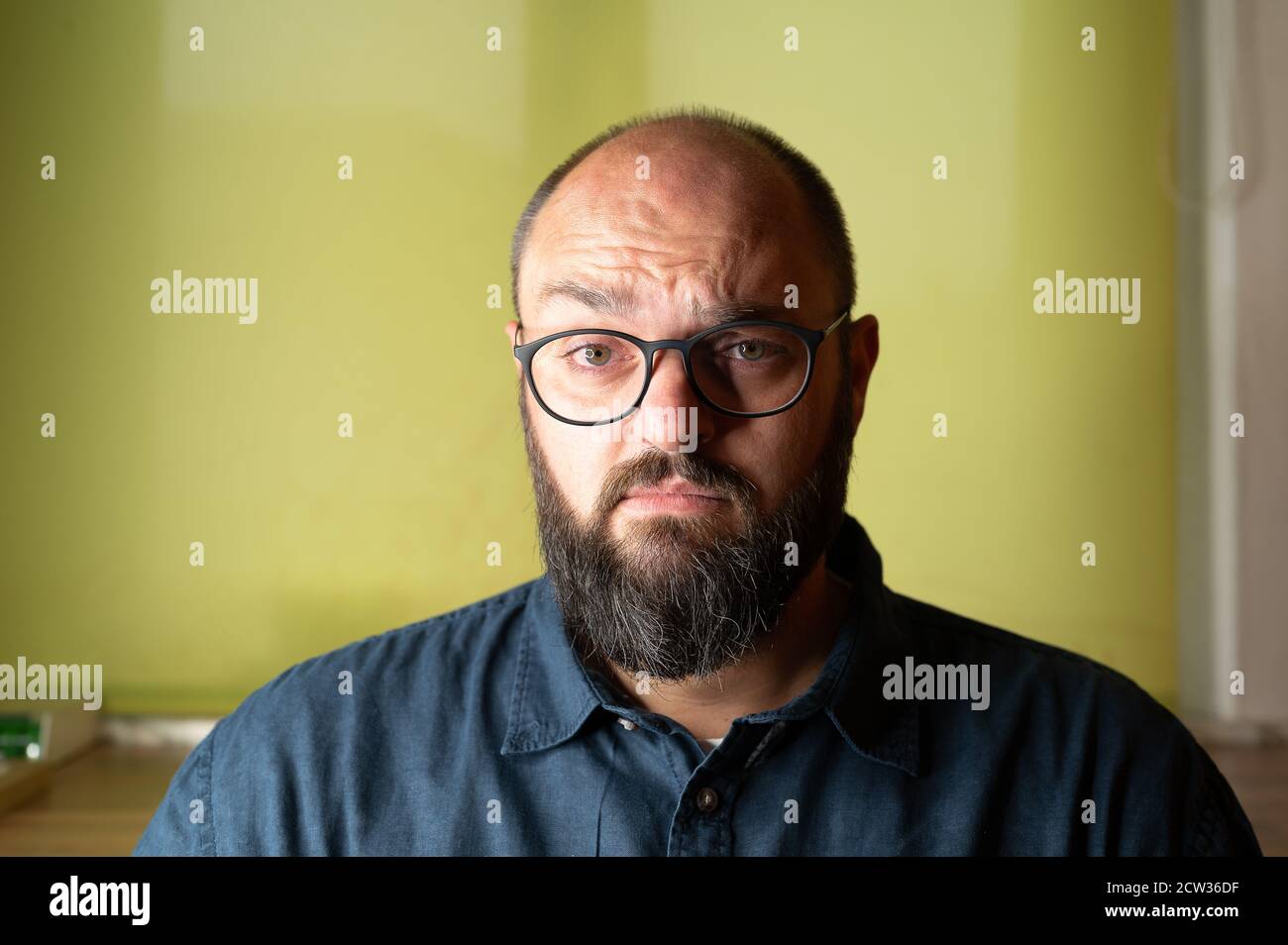 Der Mensch sieht ernsthaft unsicher und zweifelhaft in die Kamera Stockfoto