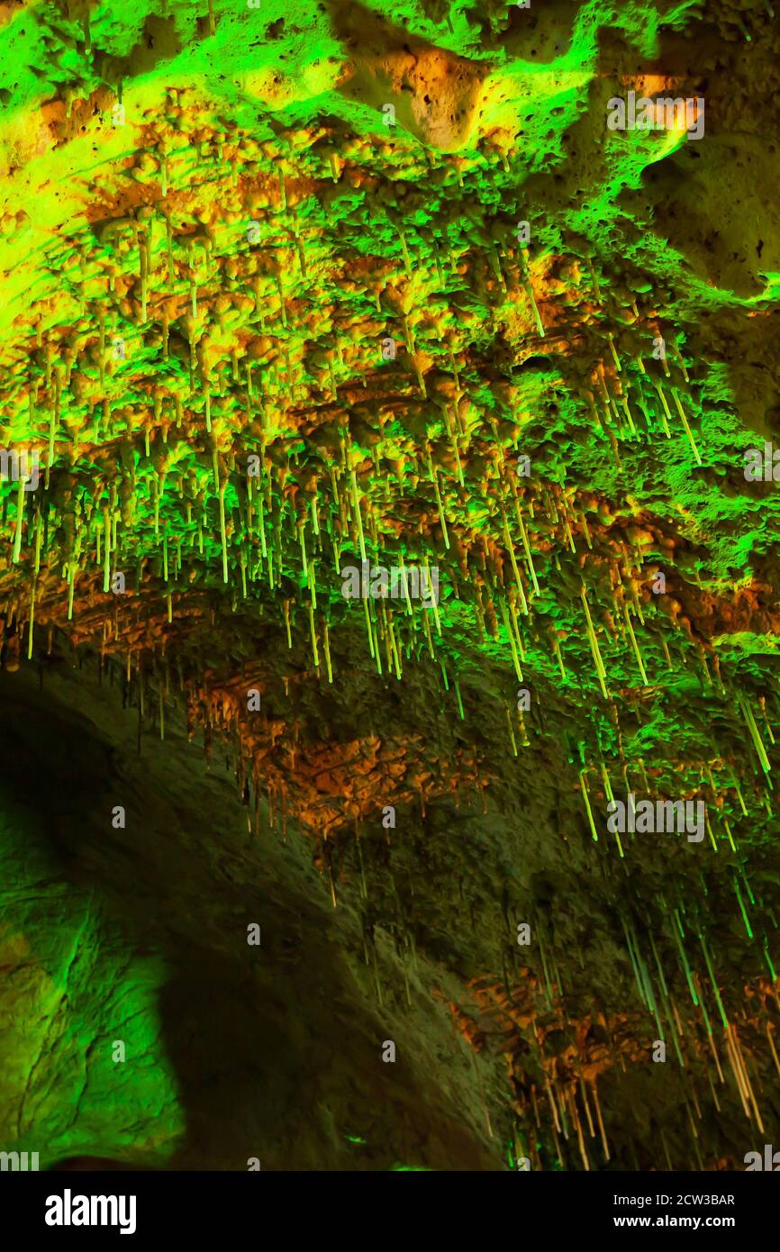 Magisches Innere der alten Kalksteinhöhle, fantastische grüne Stalagmite glüht in Lichtern. Khao Bin Cave, Ratchaburi, Thailand. Low-Angle-Ansicht. Stockfoto