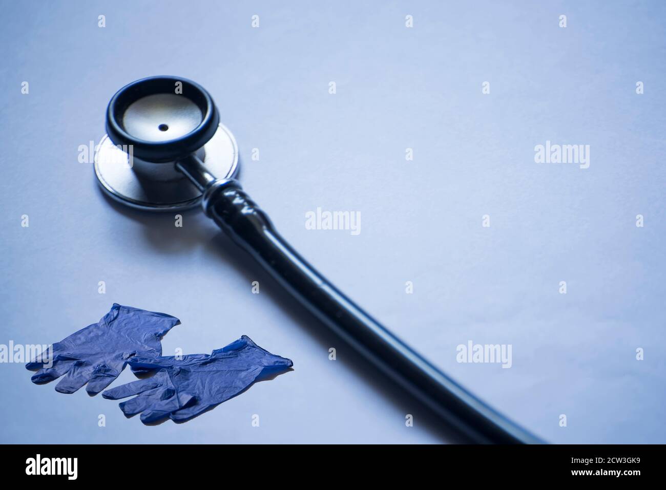Stethoskop und Handhandschuhe isoliert auf blauem Hintergrund Stockfoto