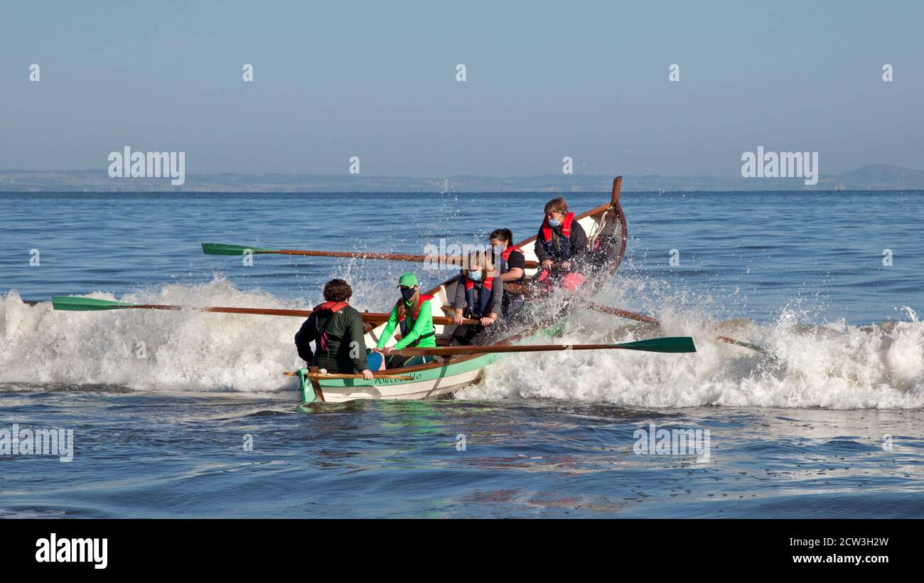 Portobello, Edinburgh, Schottland, Großbritannien. 27. September 2020. Temperatur 4 Grad nach einer kalten Nacht und Morgen, ein dramatischer geschickter Start in den Firth of Forth für das Row Porty Team. Nach einer sechsmonatigen Entlassung aufgrund der Covid-19, Coronavirus-Pandemie ist es offensichtlich, dass diese maskierte Crew ihre Ruderfähigkeiten nicht verloren hat. Stockfoto