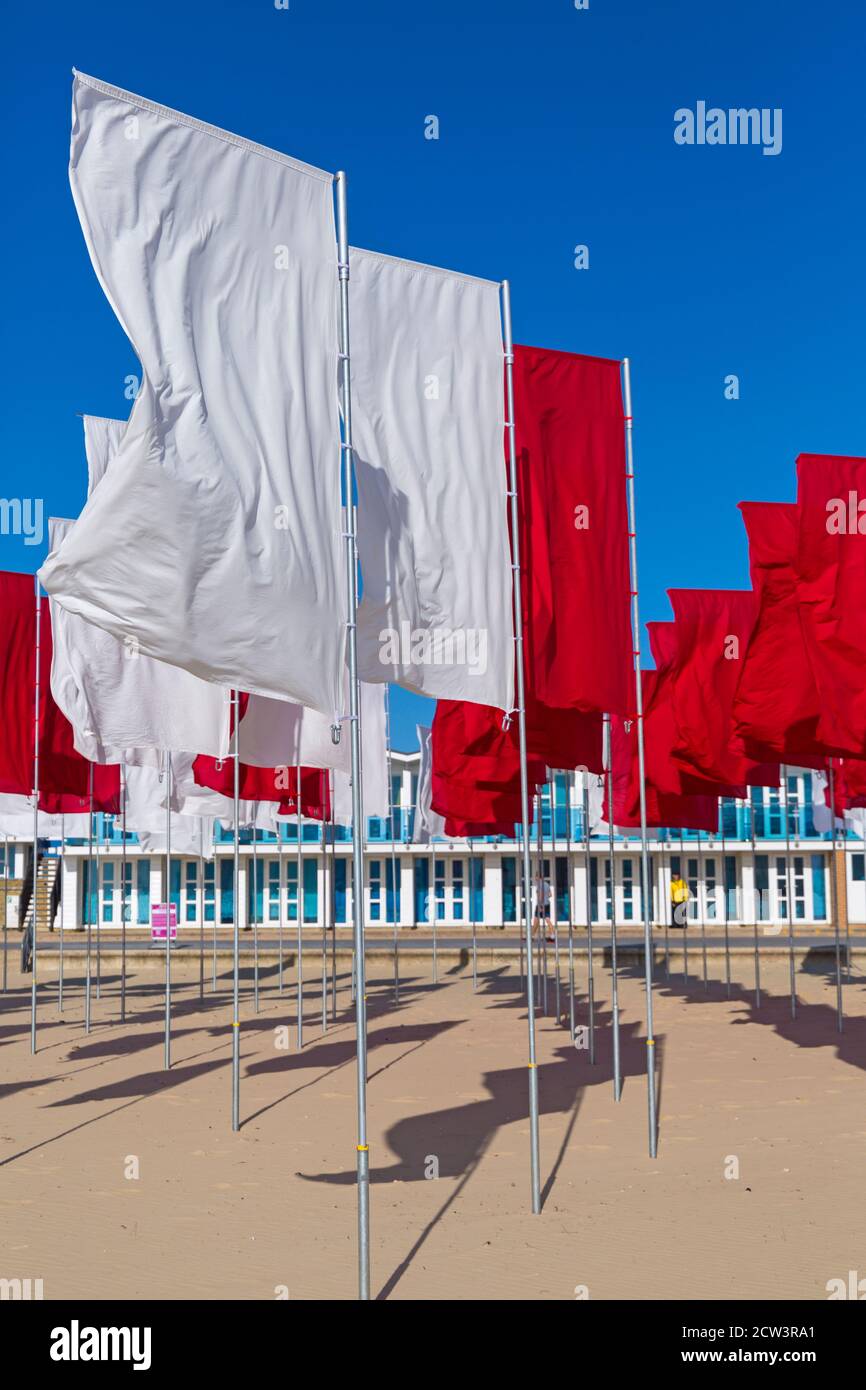 Sandbanks, Poole, Dorset, Großbritannien. September 2020. Die Menschen besuchen Luke Jerrams Kunstwerk "in Memoriam" am Strand von Sandbanks, das aus über 100 Bettlaken, einem riesigen Meer von Flaggen, geschaffen wurde, um an die Verlorenen von Covid-19 zu erinnern – Teil des Bournemouth Arts by the Sea Festivals. Die Installation ist in Form eines medizinischen Logos, eines roten Kreuzes auf weißem Hintergrund angeordnet und würdigt auch die mutigen Mitarbeiter und Freiwilligen des NHS, die weiterhin ihr Leben riskieren, um die Tausenden von Menschen zu versorgen, die vom Coronavirus betroffen sind. Quelle: Carolyn Jenkins/Alamy Live News Stockfoto