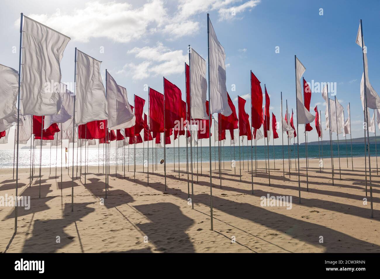 Sandbanks, Poole, Dorset, Großbritannien. September 2020. Die Menschen besuchen Luke Jerrams Kunstwerk "in Memoriam" am Strand von Sandbanks, das aus über 100 Bettlaken, einem riesigen Meer von Flaggen, geschaffen wurde, um an die Verlorenen von Covid-19 zu erinnern – Teil des Bournemouth Arts by the Sea Festivals. Die Installation ist in Form eines medizinischen Logos, eines roten Kreuzes auf weißem Hintergrund angeordnet und würdigt auch die mutigen Mitarbeiter und Freiwilligen des NHS, die weiterhin ihr Leben riskieren, um die Tausenden von Menschen zu versorgen, die vom Coronavirus betroffen sind. Quelle: Carolyn Jenkins/Alamy Live News Stockfoto