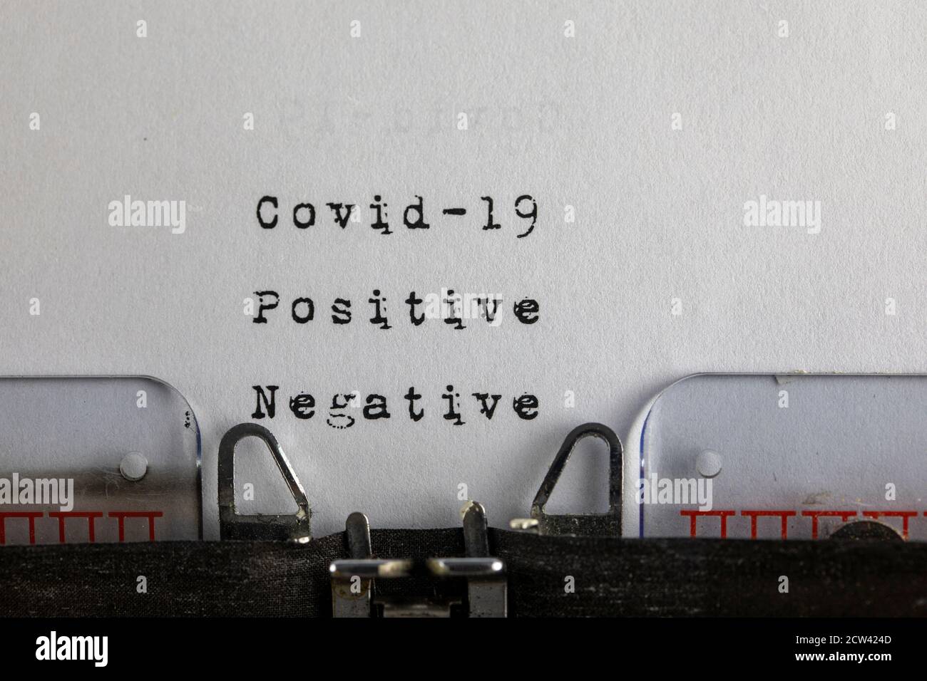 Geschrieben auf alter Schreibmaschine mit Text Covid-19 positiv - negativ, Covid-19, Coronavirus Konzept Stockfoto