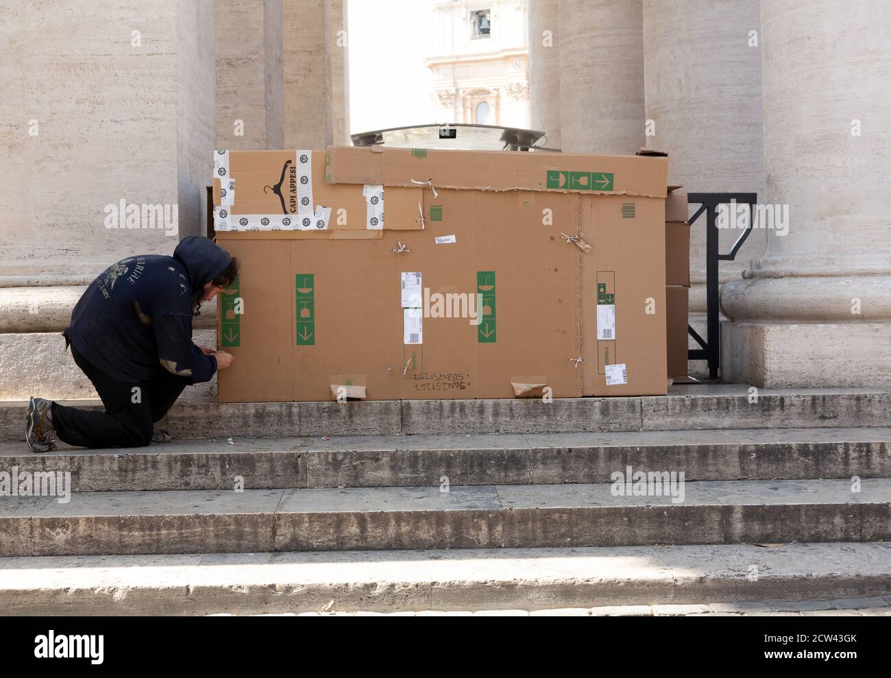 Mann mit einer großen Pappschachtel zum Schlafen rau neben dem Vatikan, Rom, Italien verwendet Stockfoto