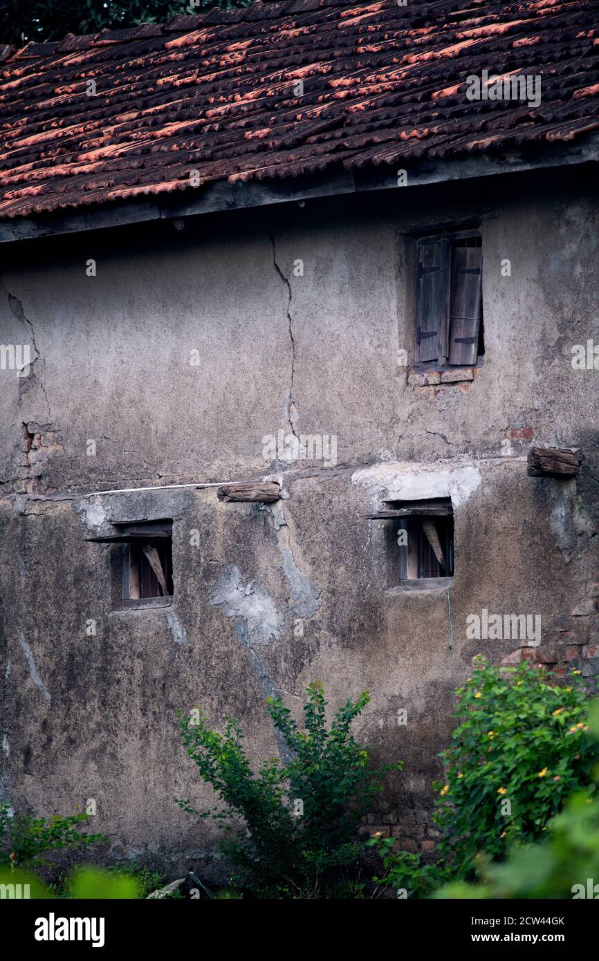 Abschnitt der Außenseite eines alten Hauses in einem Ländliche Umgebung an einem bewölkten Tag Stockfoto