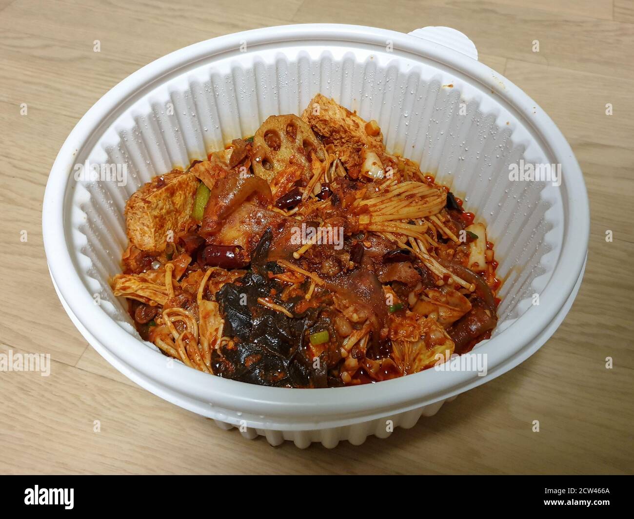 MA la xiang Pan oder Ma la xiang guo, ein chinesisches Gericht mit Fleisch und Gemüse. Würziger, betäubender Topf mit Rührbesen. Lebensmittel in der Plastikschüssel zum Mitnehmen. Stockfoto