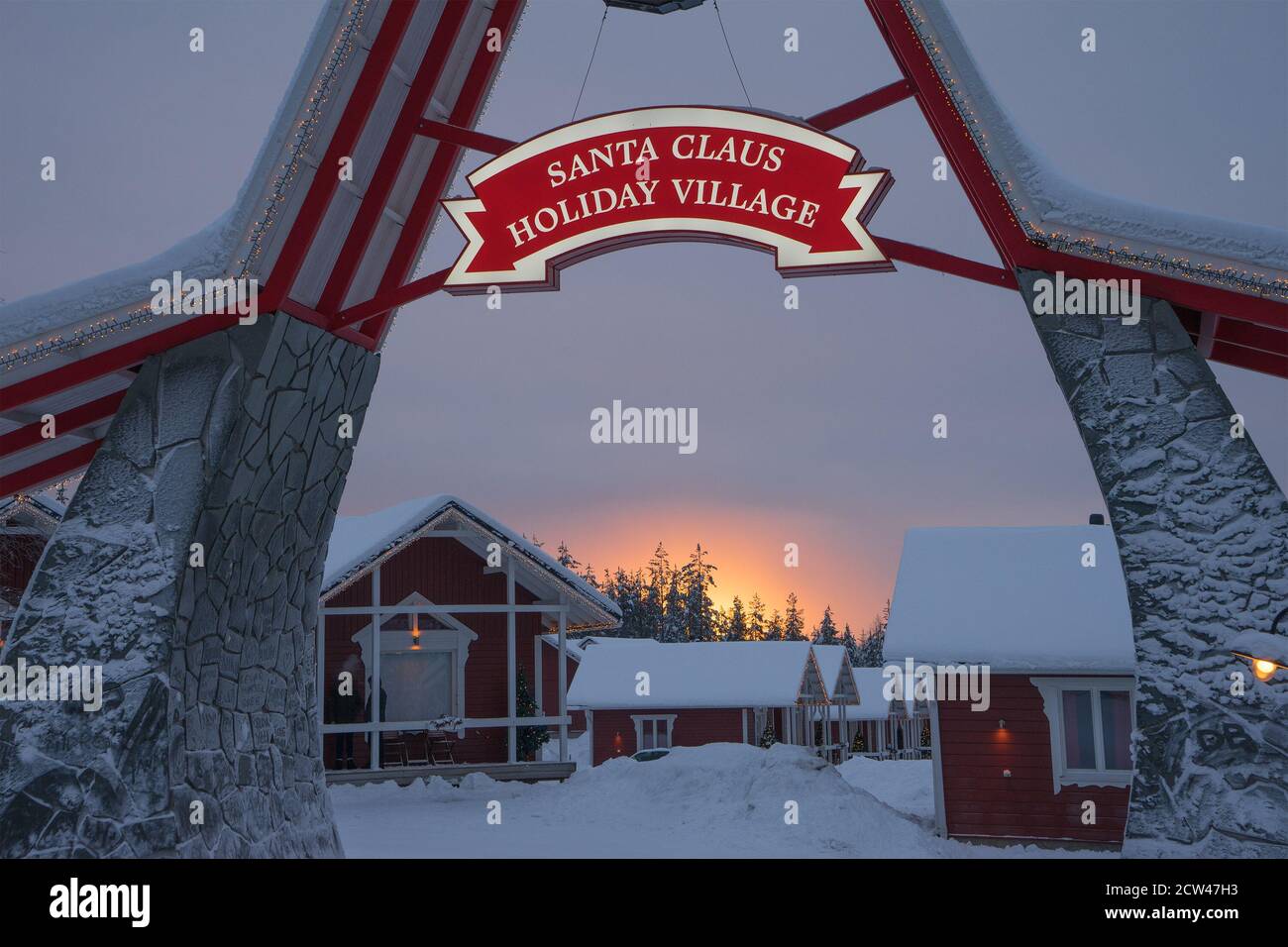 Hotel Santa Claus Holiday Village, Polarkreis, Lappland, Finnland. Leuchtendes Pink bei Sonnenuntergang. Illustratives Editorial. Platz für Text kopieren. Stockfoto
