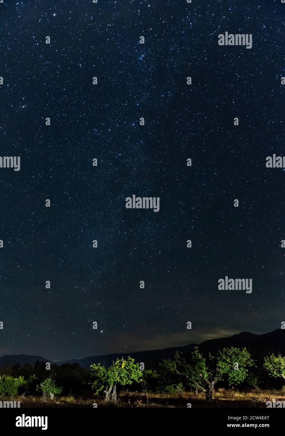 Milchstraße Galaxie Streifen in Richtung des Horizonts, während Morgenlicht zeigt sich über den Berg Silhouetten. Stockfoto