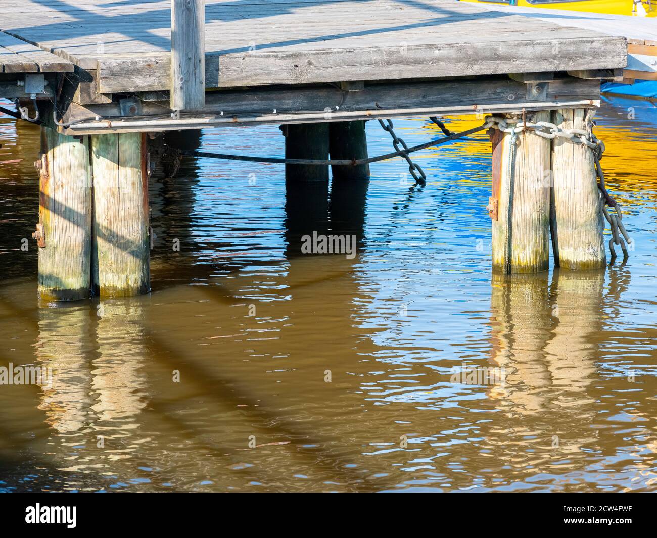 Helsinki / Finnland - 27. September 2020: Eine Nahaufnahme eines hölzernen Kai mit einigen hölzernen Abutments, die im blauen Wasser stehen. Stockfoto