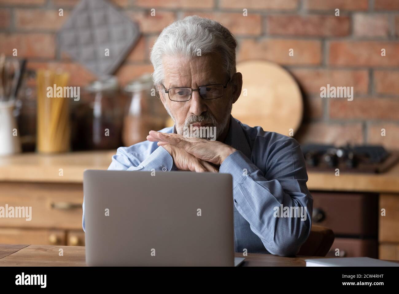 Nachdenkliche ältere Mann betrachten Laptop-Bildschirm denken Stockfoto