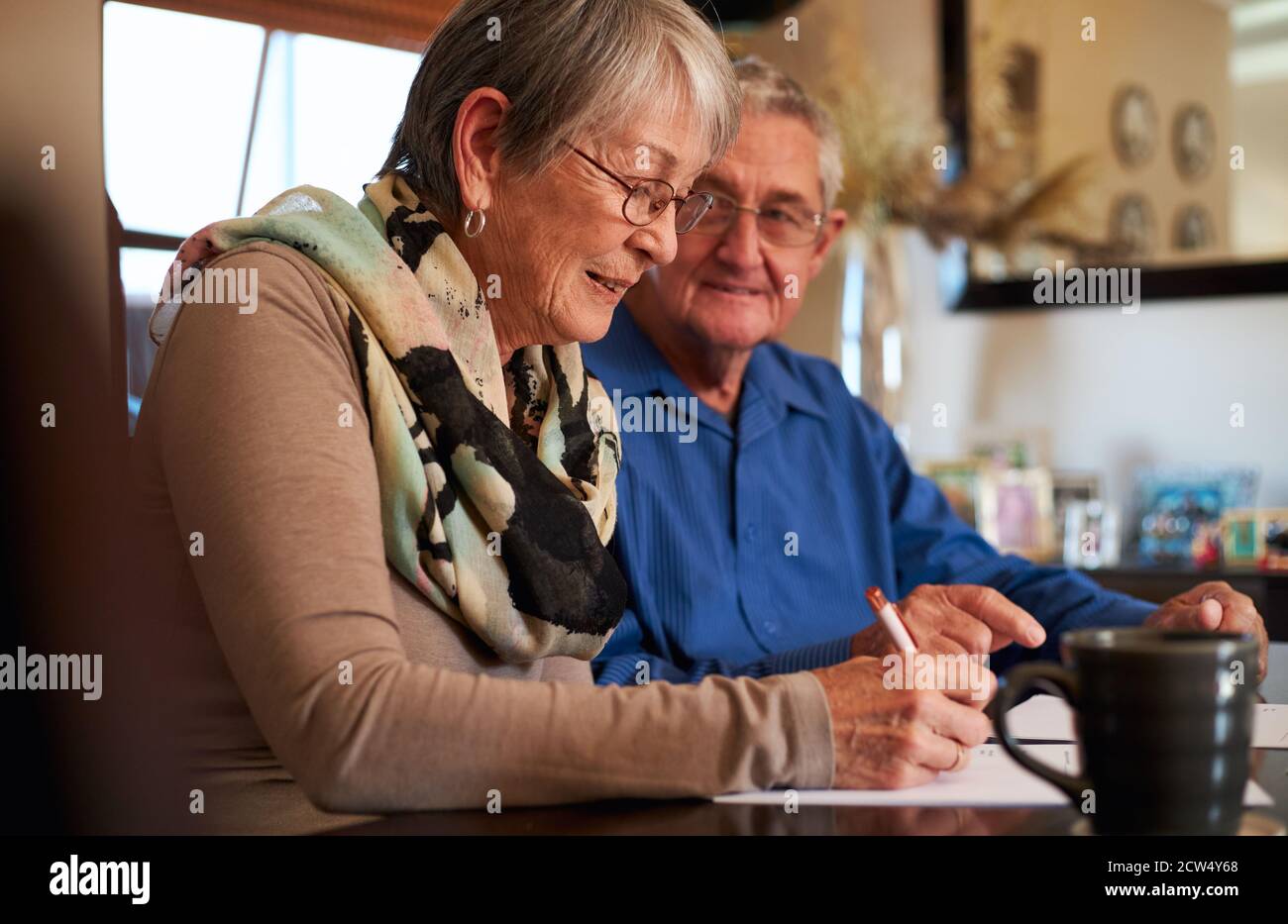 Seniorenpaar Zu Hause Am Tisch Sitzend, Persönliche Finanzen Prüfend Stockfoto