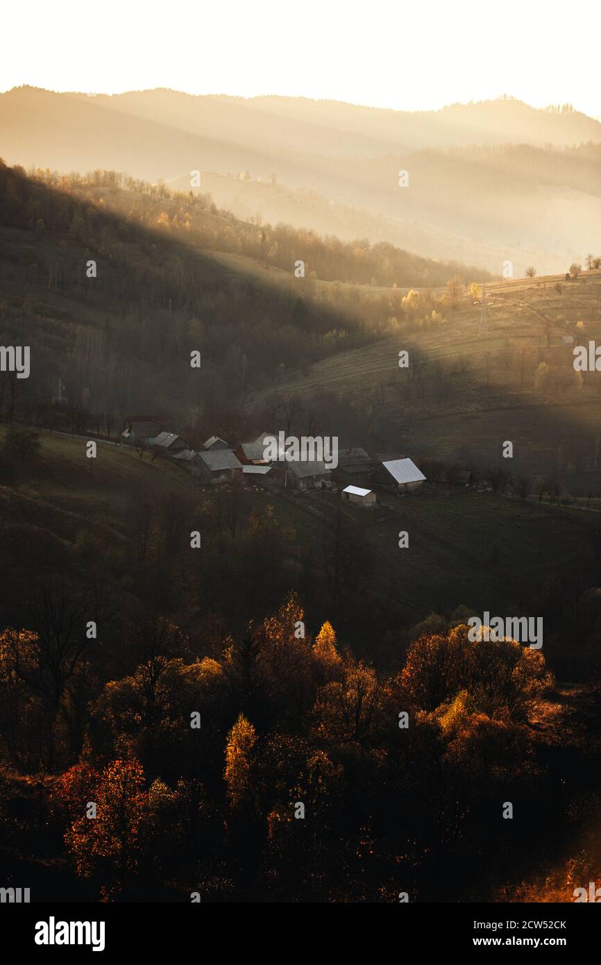 Idyllische Herbstlandschaft am frühen Morgen bei Sonnenaufgang mit bunten Bäume und beleuchtete Berge.Bucovina, Rumänien Stockfoto