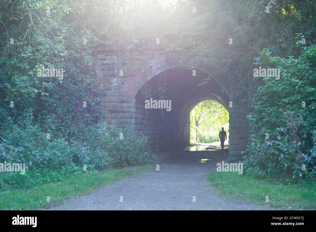 Licht am Ende des Tunnels - Standort des seit langem geschlossenen Molyneux Brow Railway Station, Clifton, England. Person im Tunnel, Silhouette Stockfoto