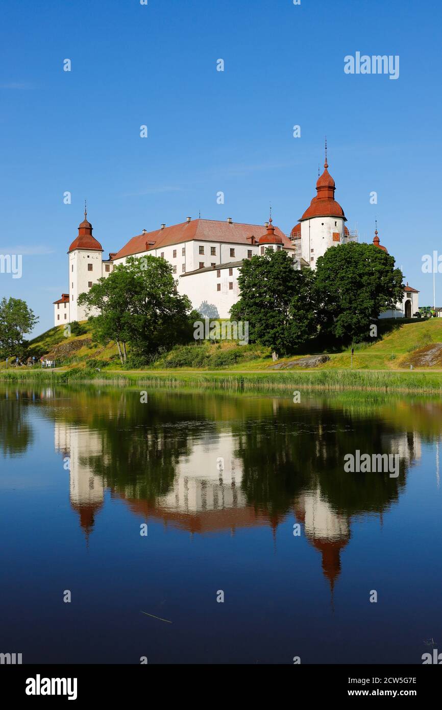 Blick auf das mittelalterliche schwedische Schloss Lacko mit seiner Spiegelung im See. Stockfoto