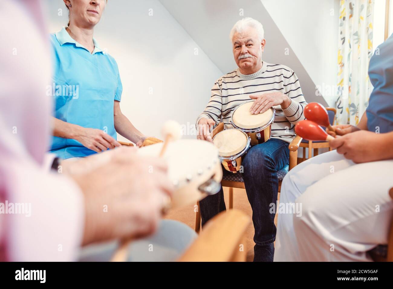 Senioren im Pflegeheim Musik machen mit Rhythmus Instrumente Stockfoto