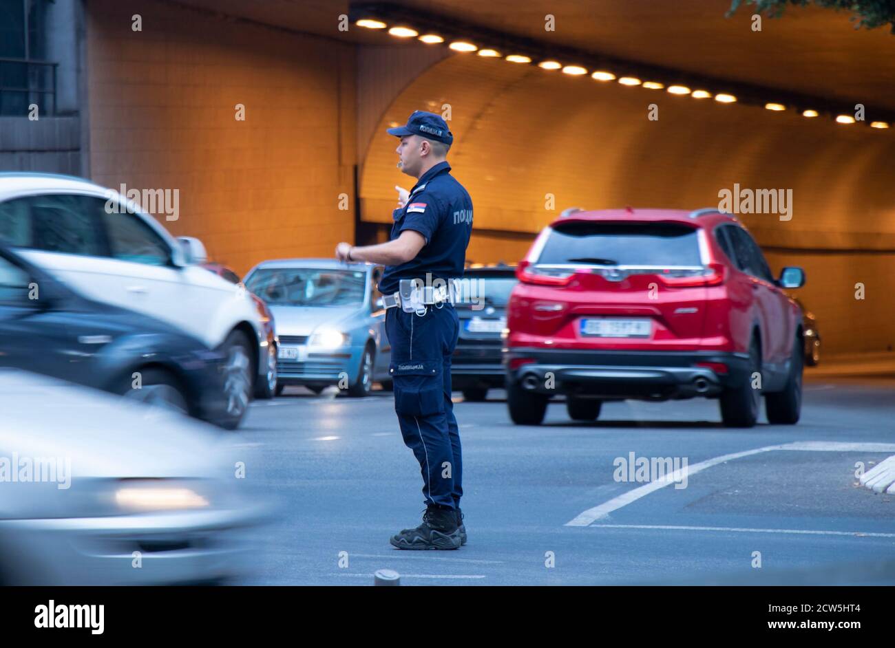 Belgrad, Serbien - 25. September 2020: Polizist im Dienst, steht in der Kreuzung mit Verkehr in Bewegung Unschärfe Stockfoto