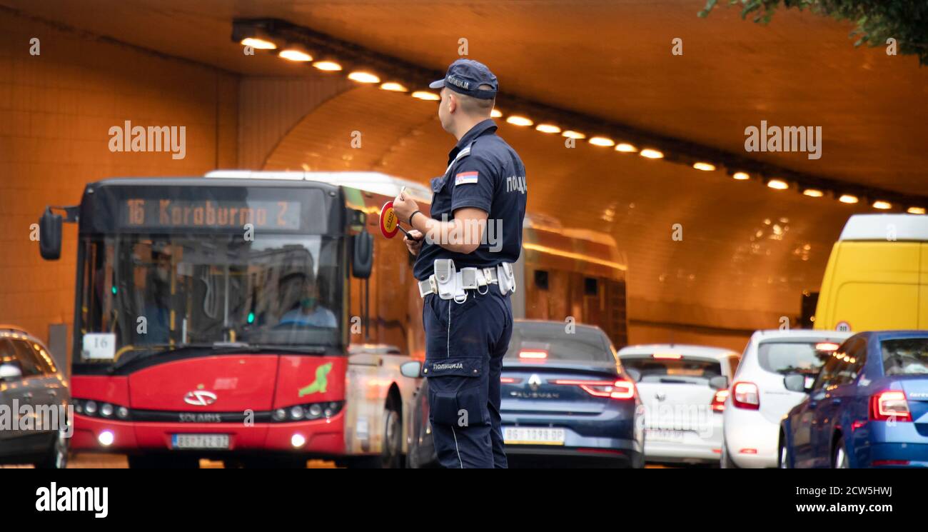 Belgrad, Serbien - 25. September 2020: Polizist im Dienst, steht in der Kreuzung mit Verkehr in Bewegung Unschärfe Stockfoto