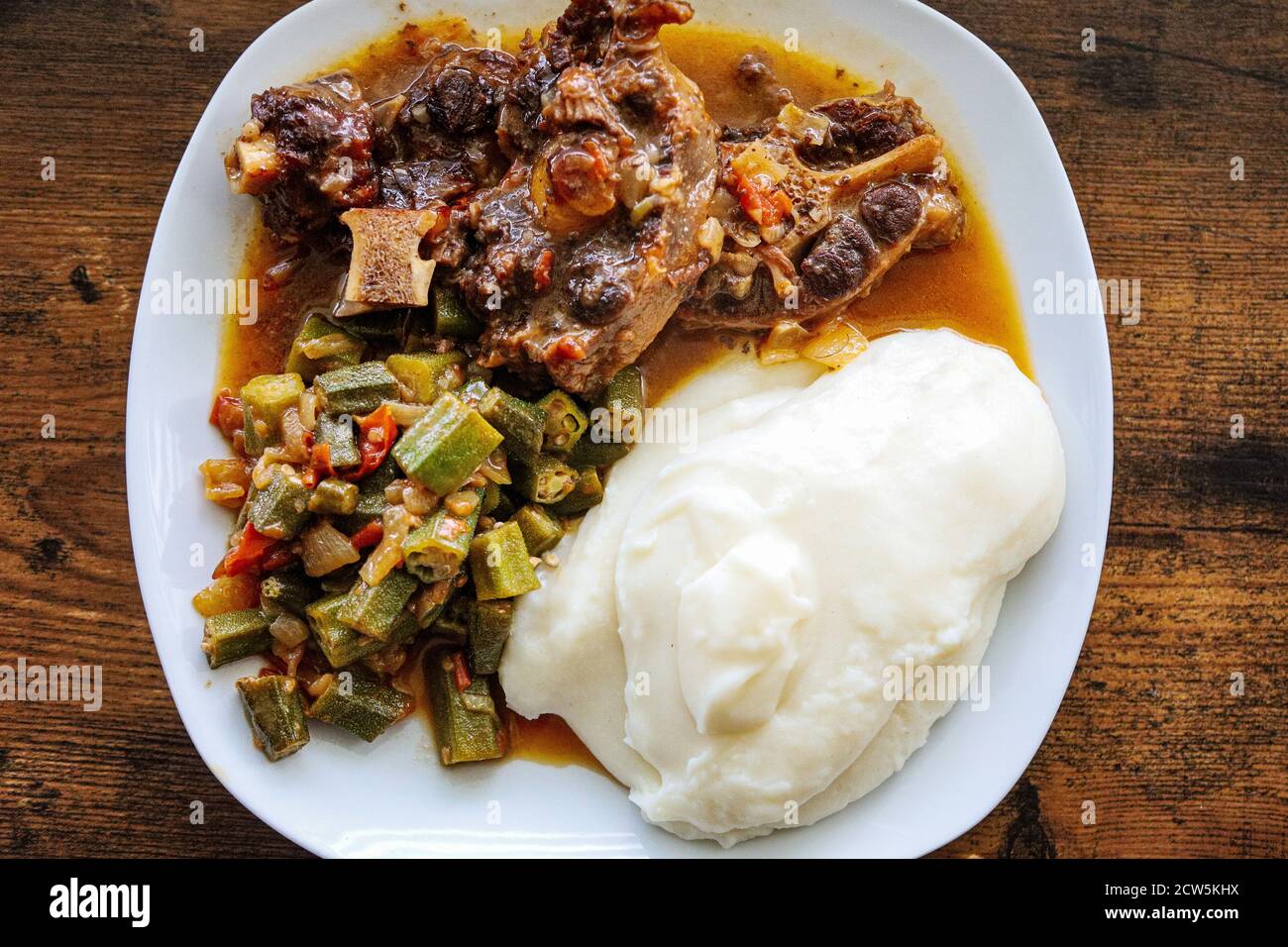 Ein Teller mit malawianischen Essen nsima mit Ochsenschwanz und Okra In Soße Stockfoto