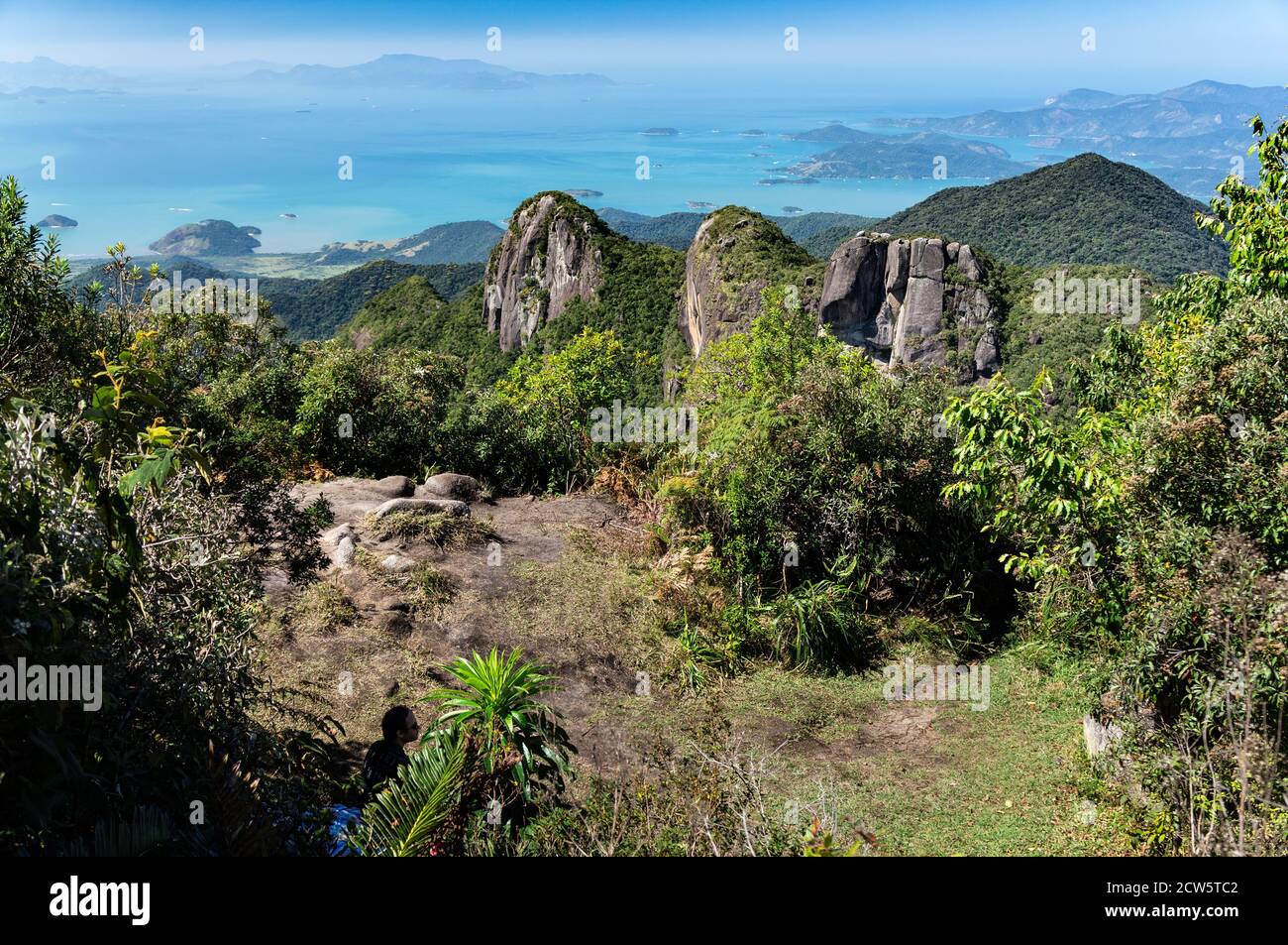 Eine kleine Ebene zwischen den Aussichtsplätzen von Pedra da Macela Wahrzeichen umgeben von Vegetation mit den drei Felsformationen. Stockfoto