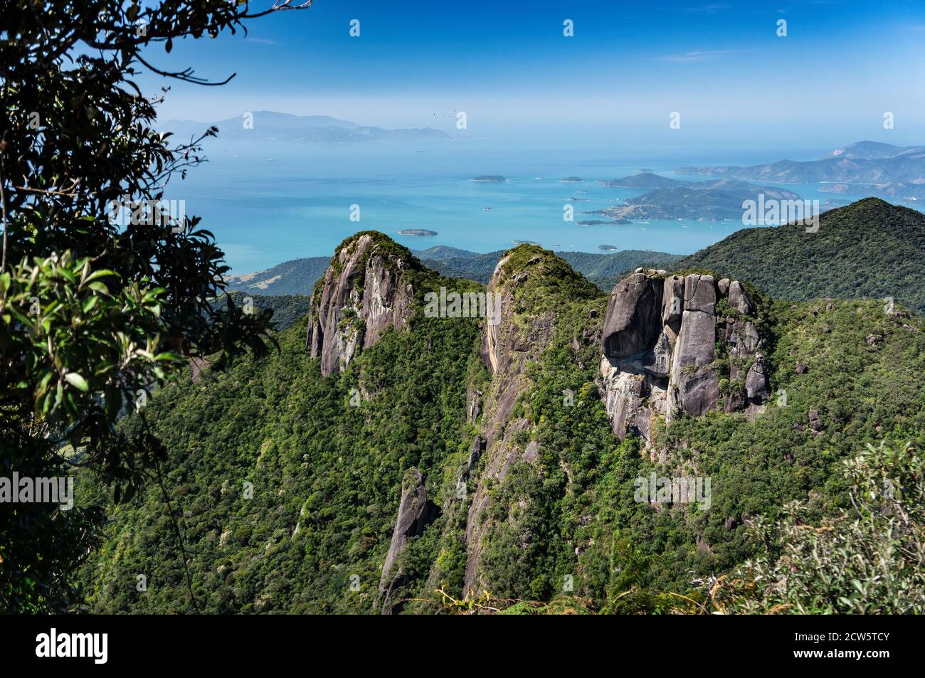 Die atemberaubenden drei Felsenformationen Gipfel mit Serra do Mar grüne Vegetation mit Carioca Bucht Küste im Hintergrund bedeckt. Stockfoto